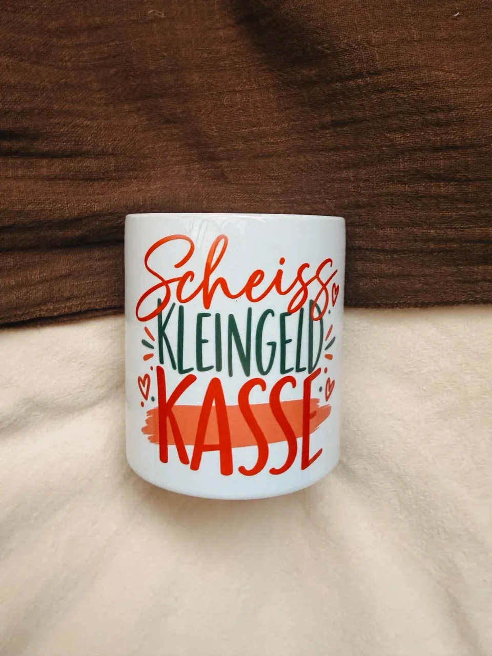 Weiße Spardose mit der Aufschrift „Scheiss Kleingeld Kasse“